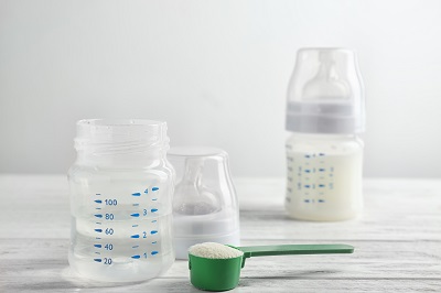 Bottle of water and powder for preparing baby formula by Africa Studio/stock.adobe.com.